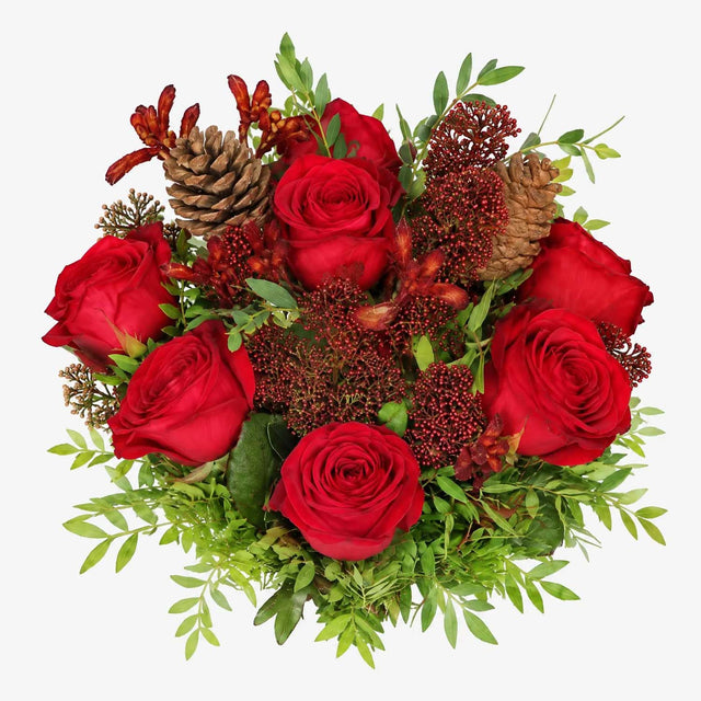 Overhead view of red roses and skimmia in The Crimson Christmas bouquet