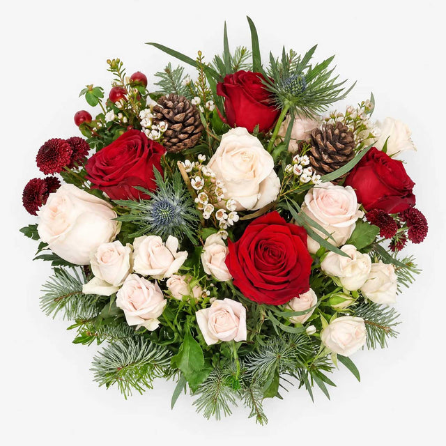 Overhed view of red roses and cream spray roses in The Noel Christmas bouquet