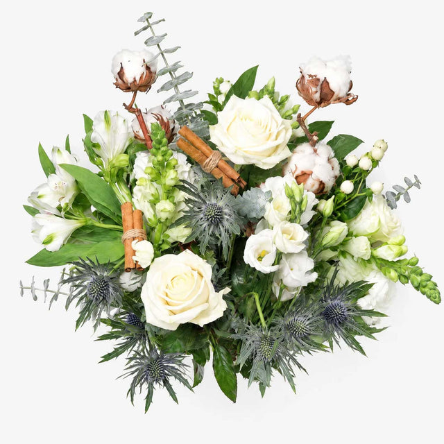 Close-up of white roses, carnations and red hypericum berries in The Snowdrop Christmas bouquet
