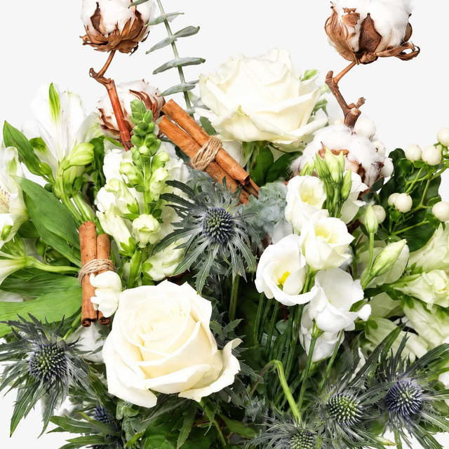 The Snowdrop white Christmas bouquet with cotton pods and cinnamon sticks, wrapped with a handwritten card