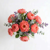Close-up of coral peony bouquet with limonium detail.