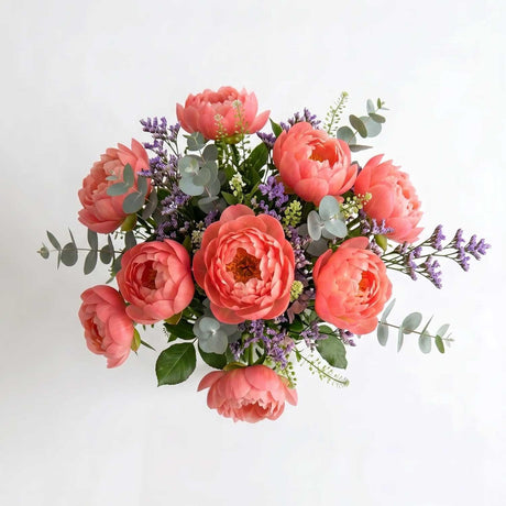 Close-up of coral peony bouquet with limonium detail.